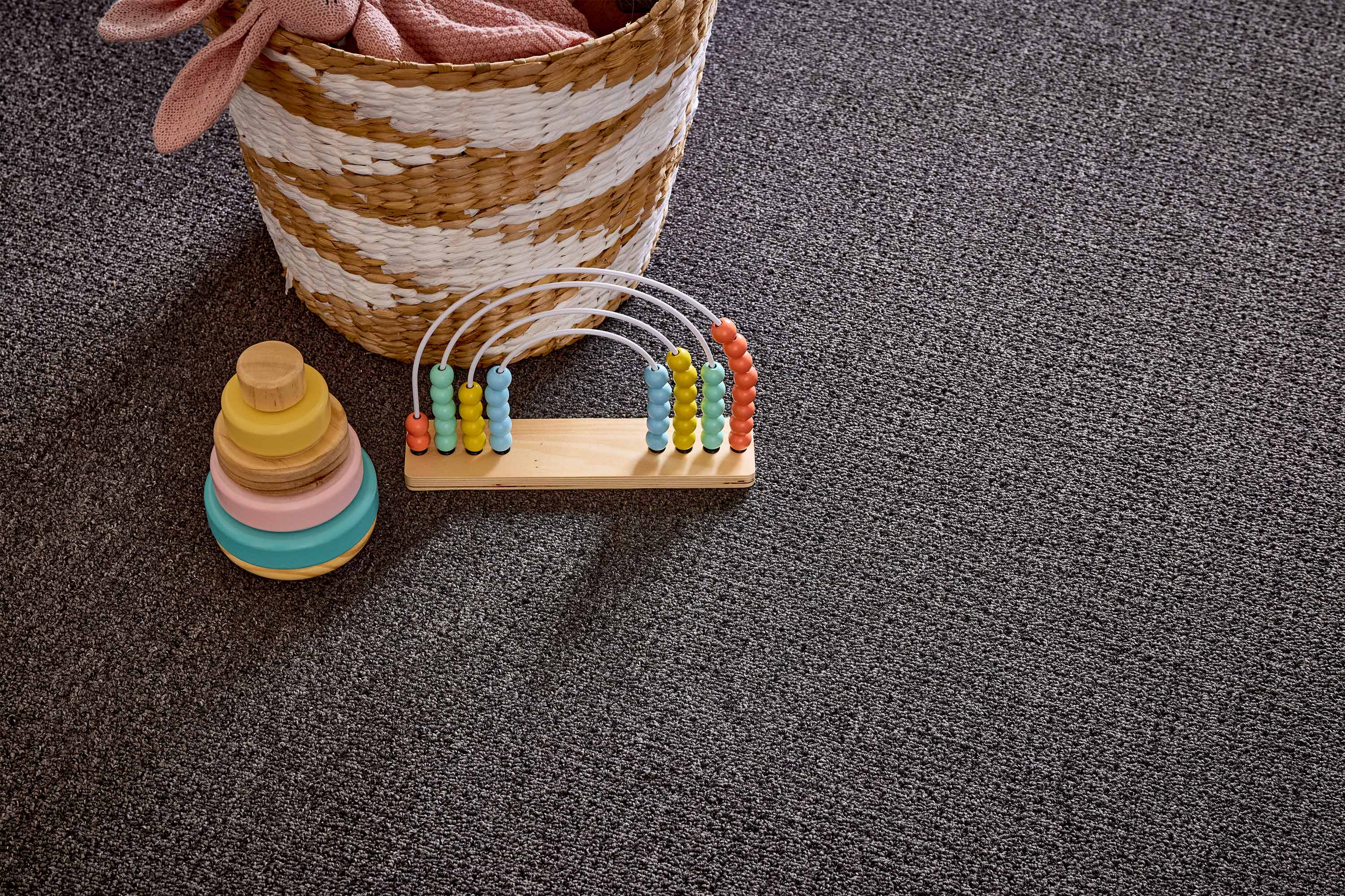 Revolution textured loop carpet shown beside a woven basket and abacus